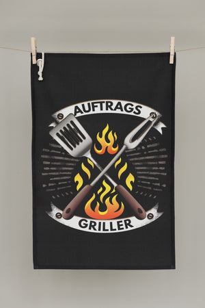 Nachhaltiges Geschirrtuch „AuftragsGriller“ von CALEO d.sign mit BBQ Motiv, Grillbesteck und Flammen