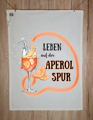 Modernes Geschirrtuch mit lustigem Aperol Spruch und Cocktail Motiv, nachhaltiges Küchenhandtuch mit orangenen Akzenten und Öse zum Aufhängen.