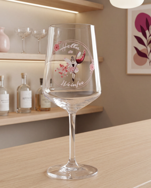 Modernes Weinglas „Holla die Weinfee“ mit filigranem rosa Design auf einer stilvollen Bar-Theke mit dekorativem Hintergrund